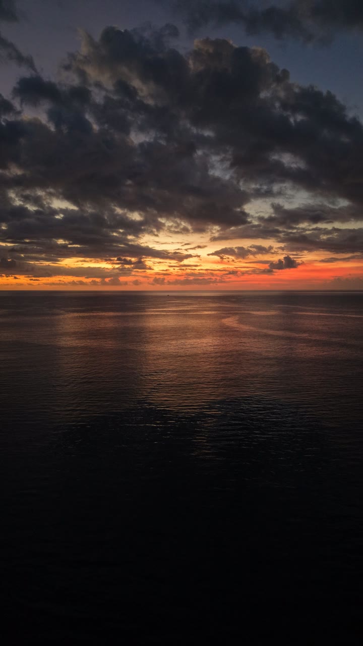 Open sea under heavy cloud at sunset