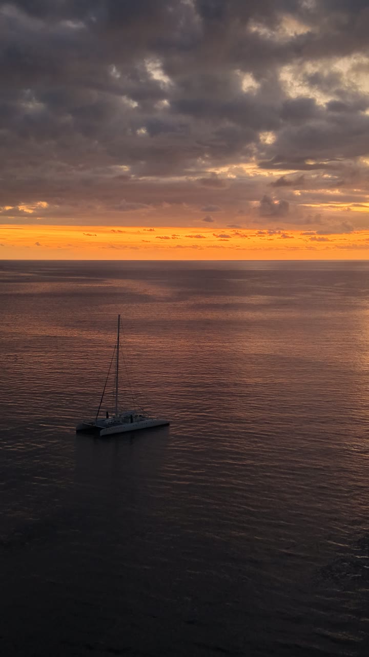 Catamaran anchored on a calm sea at sunset